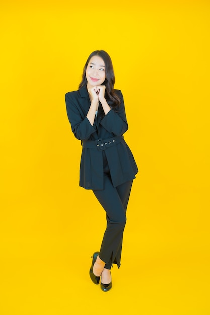 Portrait beautiful young asian woman smile with action on yellow