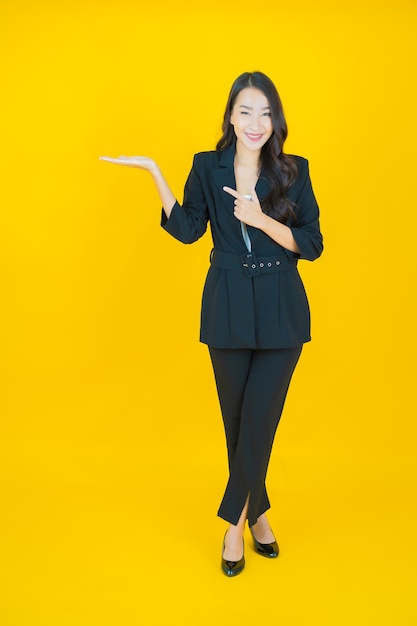 Portrait beautiful young asian woman smile with action on yellow