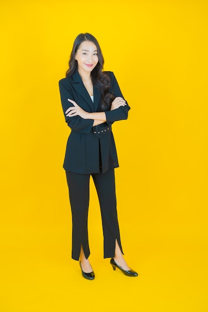Ritratto bella giovane donna asiatica sorriso con azione su yellow