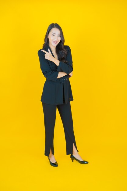 Portrait beautiful young asian woman smile with action on yellow