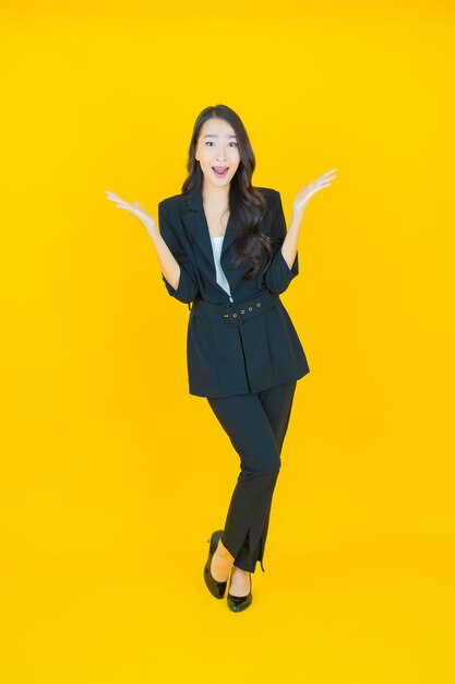 Portrait beautiful young asian woman smile with action on yellow