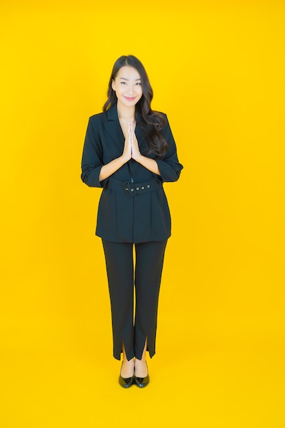 Portrait beautiful young asian woman smile with action on yellow