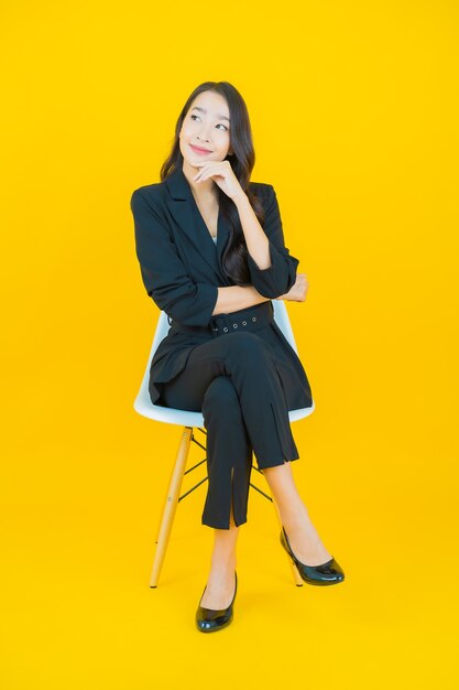 Portrait beautiful young asian woman smile with action on yellow