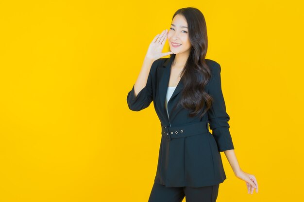 Portrait beautiful young asian woman smile with action on yellow