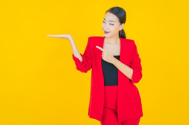 Portrait beautiful young asian woman smile with action on yellow