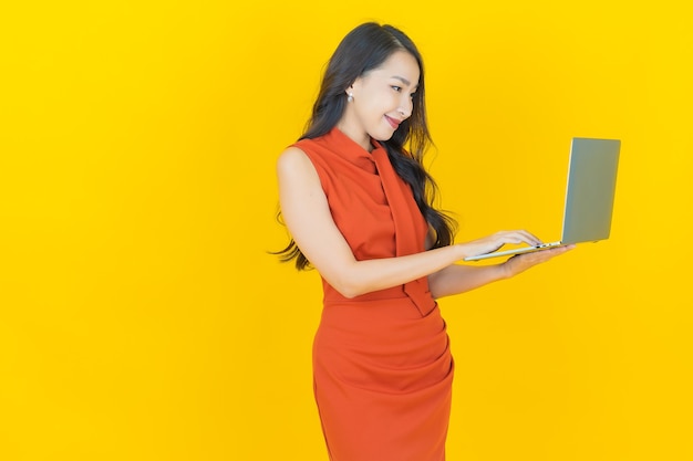고립 된 배경에 컴퓨터 노트북과 초상화 아름 다운 젊은 아시아 여자 미소