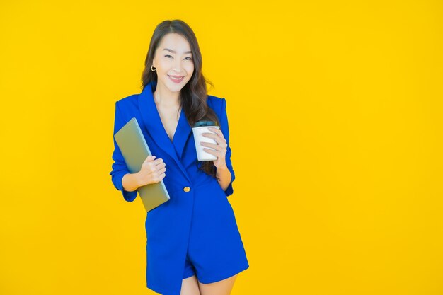 Улыбка женщины портрета красивая молодая азиатская с компьтер-книжкой компьютера на изолированной предпосылке