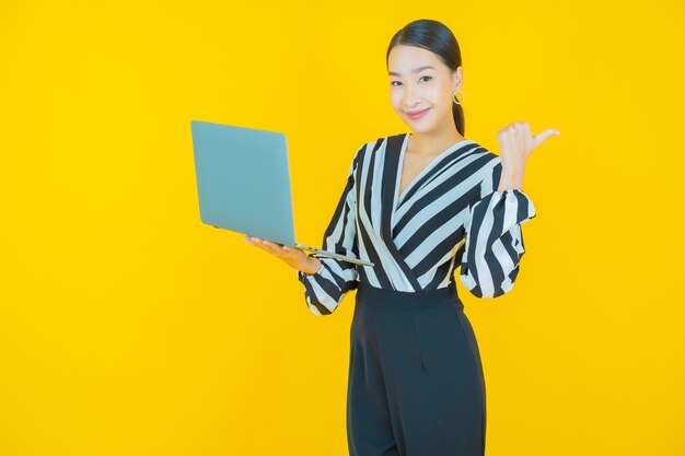 Portrait beautiful young asian woman smile with computer laptop on isolated background