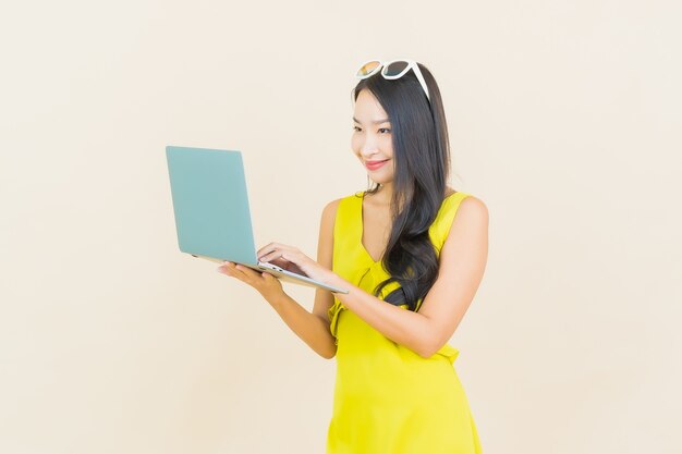 격리 된 벽에 컴퓨터 노트북과 초상화 아름 다운 젊은 아시아 여자 미소