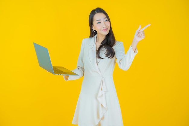 고립 된 배경에 컴퓨터 노트북과 초상화 아름 다운 젊은 아시아 여자 미소 무료 사진