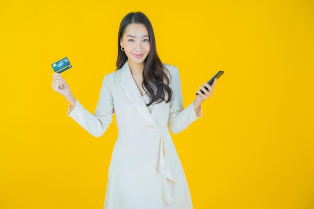 Portrait beautiful young asian woman smile with credit card on color background