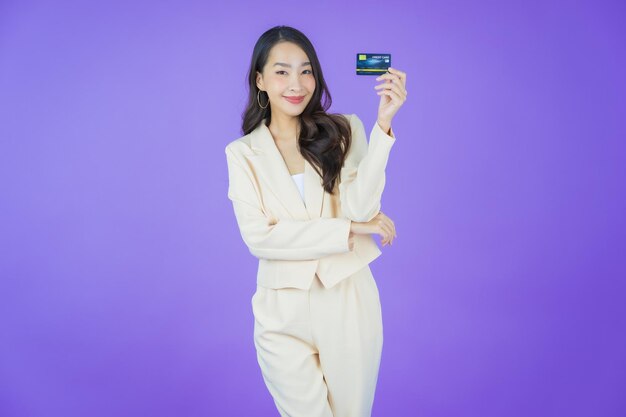 색상 배경에 신용 카드와 함께 초상화 아름 다운 젊은 아시아 여자 미소