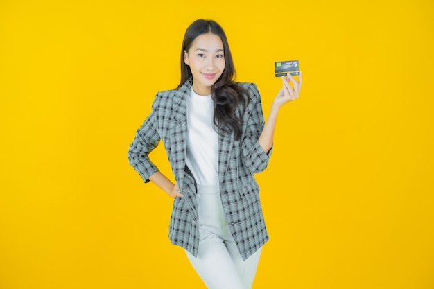 색상 배경에 신용 카드와 함께 초상화 아름 다운 젊은 아시아 여자 미소
