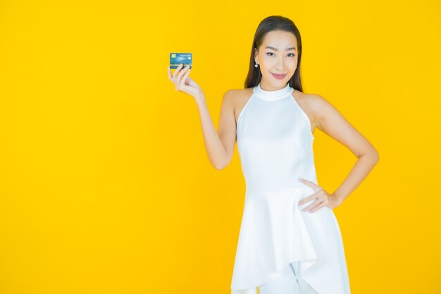 Portrait beautiful young asian woman smile with credit card on yellow