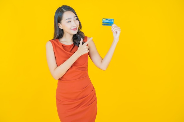 Portrait beautiful young asian woman smile with credit card on yellow