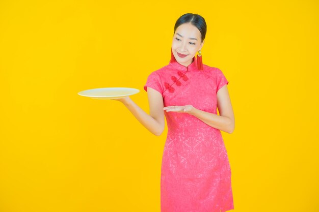 Portrait beautiful young asian woman smile with empty plate dish on color background