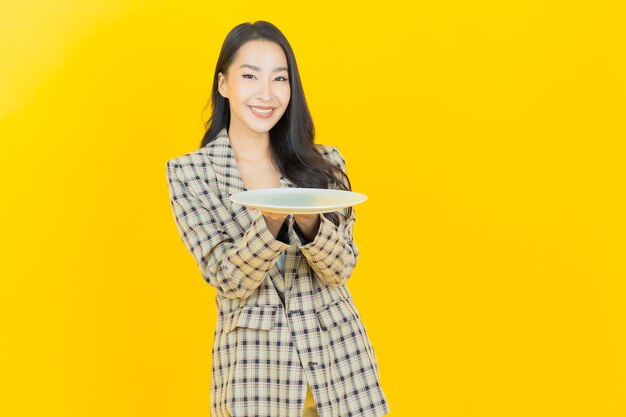 Улыбка женщины портрета красивая молодая азиатская с пустой тарелкой