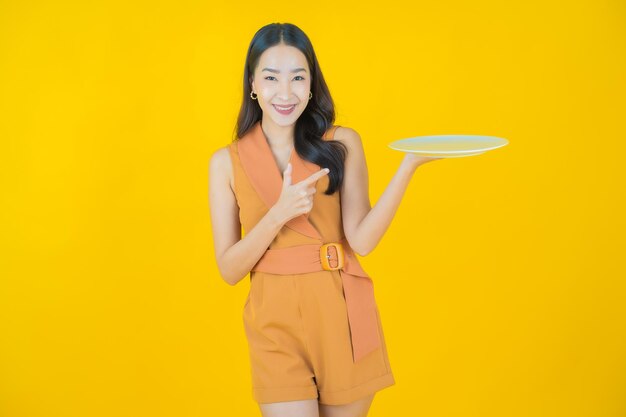 Portrait of beautiful  young asian woman smile with empty plate dish  