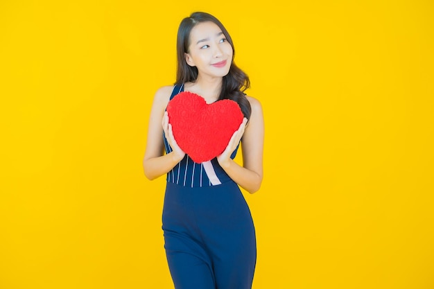 Улыбка женщины портрета красивая молодая азиатская с формой подушки сердца на