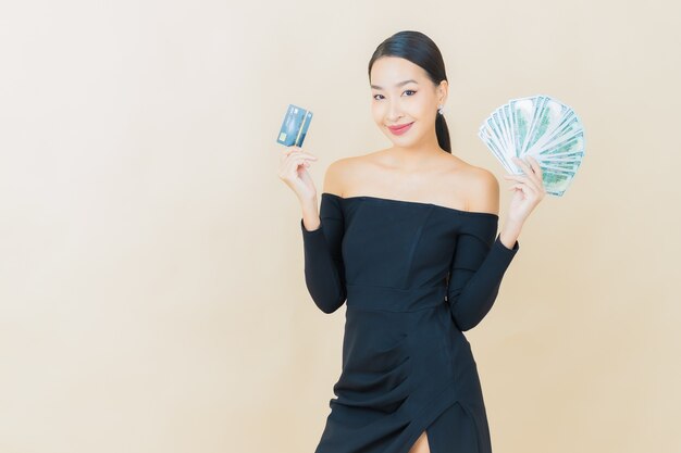 Portrait beautiful young asian woman smile with a lot of cash and money on yellow