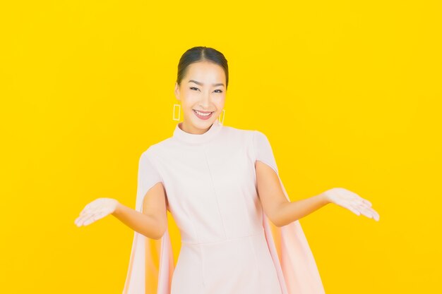 Portrait beautiful young asian woman smile with many action on yellow wall