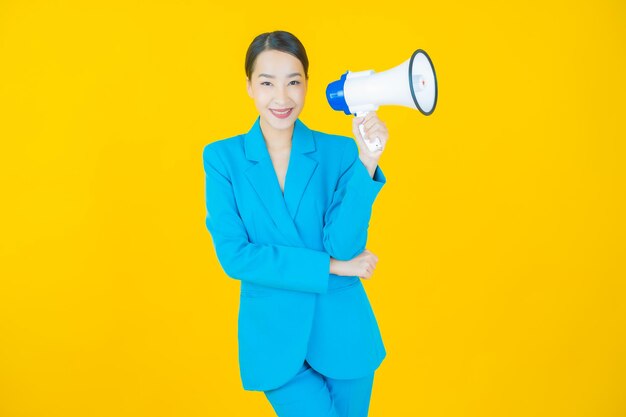 Portrait beautiful young asian woman smile with megaphone on yellow