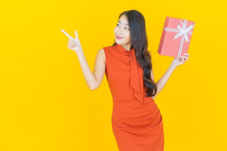 免費 Photo 画像美丽的年轻亚洲女人在黄色上微笑着红色的礼物盒
