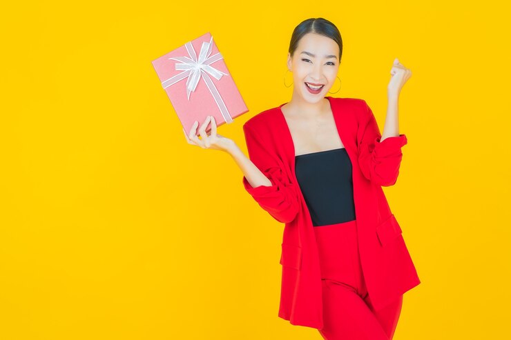 免費 Photo 画像美丽的年轻亚洲女人在黄色上微笑着红色的礼物盒