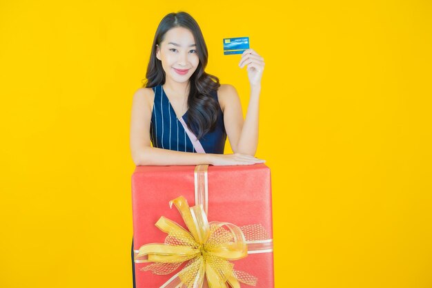 세로 아름 다운 젊은 아시아 여자 미소에 빨간 선물 상자