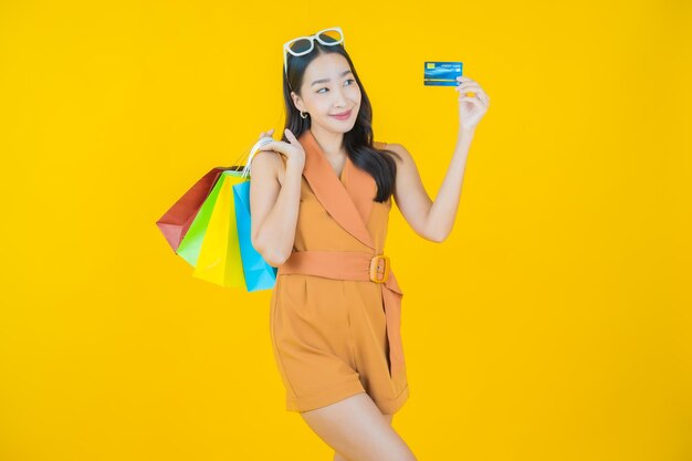 ショッピングバッグと笑顔の美しい若いアジアの女性の肖像画