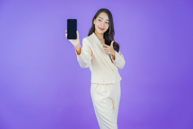 색상 배경에 스마트 휴대 전화와 함께 초상화 아름 다운 젊은 아시아 여자 미소