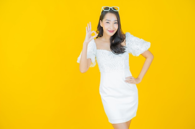 Portrait beautiful young asian woman smile on yellow