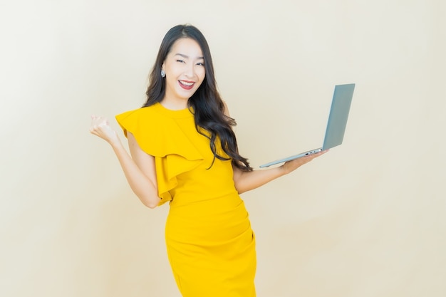 Portrait beautiful young asian woman smiles with computer laptop on isolated background