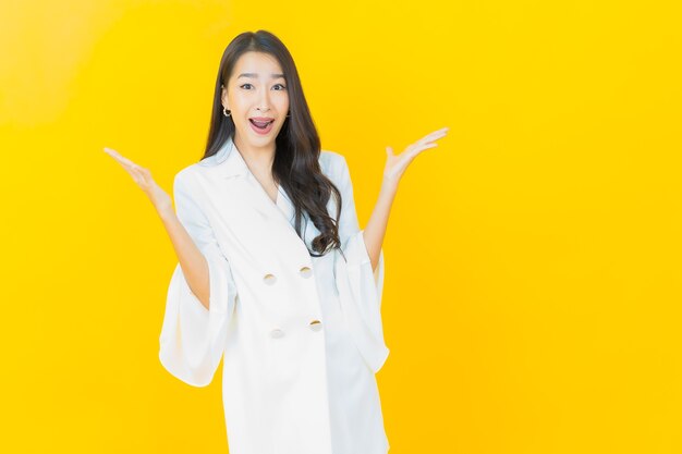 Portrait of beautiful young asian woman smiles on yellow wall