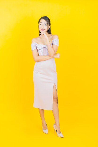 Portrait beautiful young asian woman smiling and posing on color wall