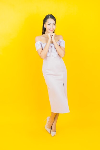 Portrait beautiful young asian woman smiling and posing on color wall