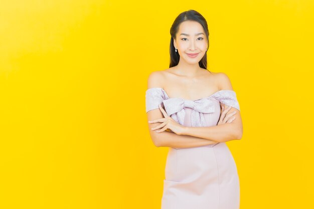 Portrait beautiful young asian woman smiling and posing on color wall