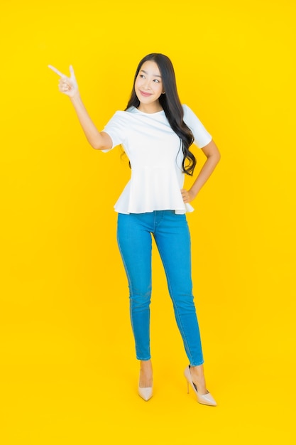 노란색에 웃는 초상화 아름 다운 젊은 아시아 여자