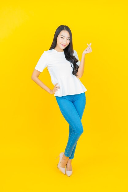 黄色に笑みを浮かべて美しい若いアジア女性の肖像画