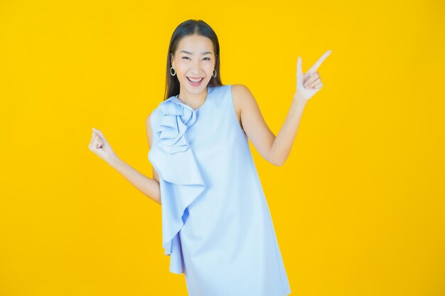 Portrait beautiful young asian woman smiling on yellow