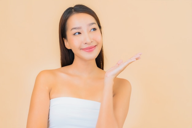 Portrait beautiful young asian woman in spa with natural make up on beige