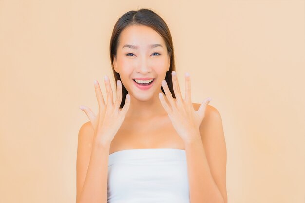 Portrait beautiful young asian woman in spa with natural make up on beige