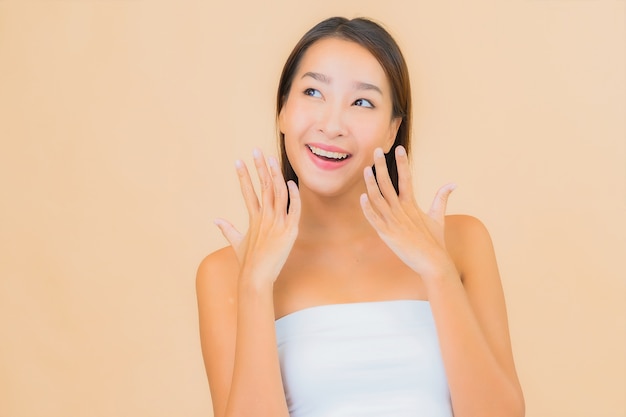 Portrait beautiful young asian woman in spa with natural make up on beige