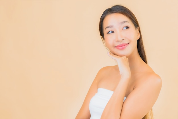 Free photo portrait beautiful young asian woman in spa with natural makeup on beige