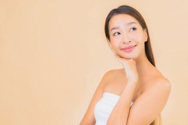 Portrait beautiful young asian woman in spa with natural makeup on beige