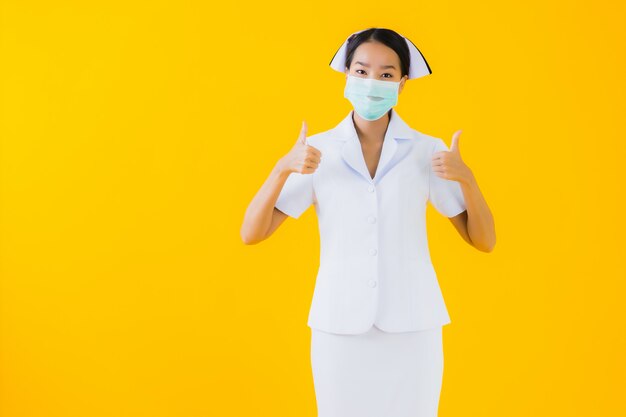 肖像画の美しい若いアジア女性タイの看護師はcovid19またはコロナウイルスを保護するためのマスクを着用します