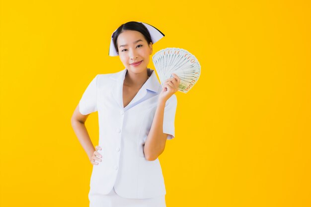현금과 돈을 많이 가진 초상화 아름 다운 젊은 아시아 여자 타이 간호사