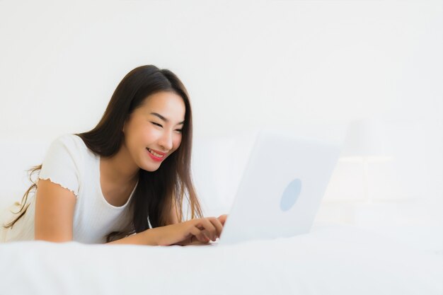 침대에서 초상화 아름 다운 젊은 아시아 여자 사용 컴퓨터 노트북