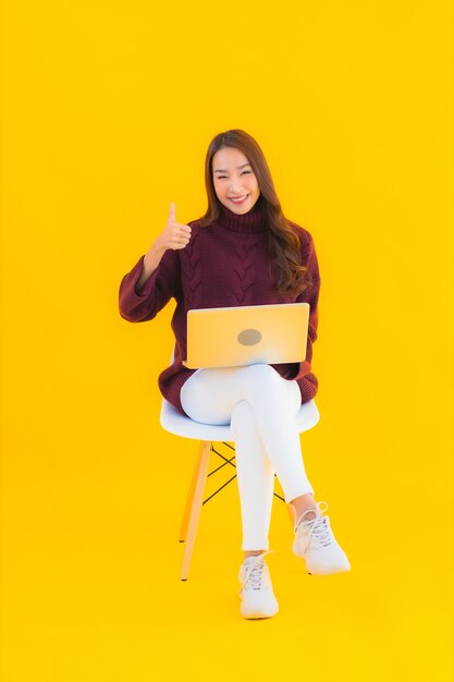 Компьтер-книжка компьютера пользы женщины портрета красивая молодая азиатская