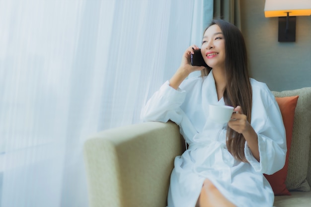 Portrait beautiful young asian woman use smart mobile phone on sofa